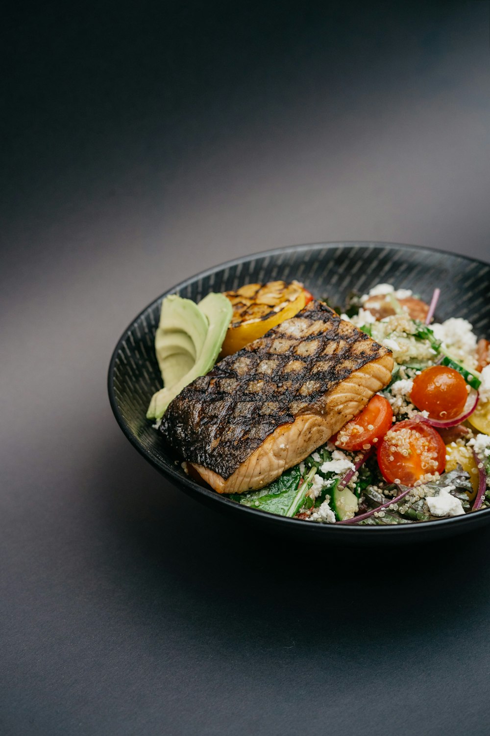 grilled meat with green vegetable on black ceramic plate