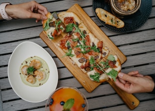 sliced pizza on brown wooden chopping board