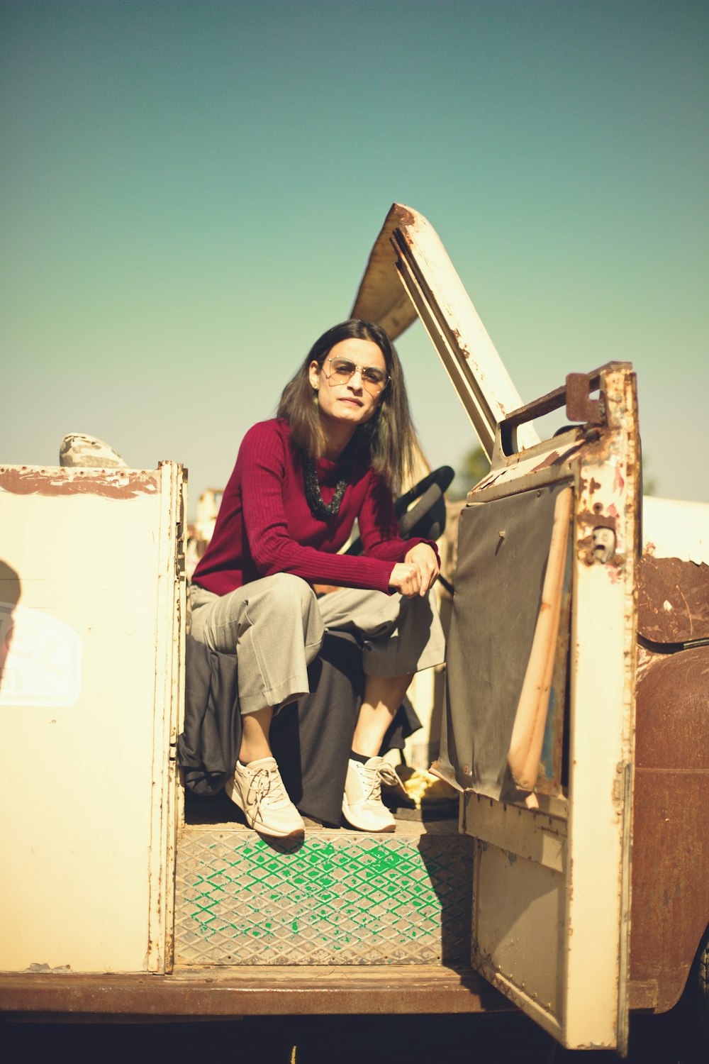 woman in red long sleeve shirt sitting on white box