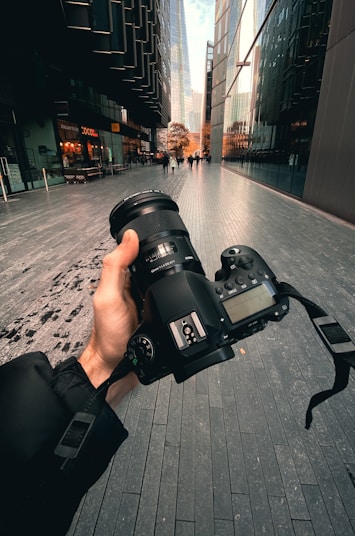 person holding black dslr camera