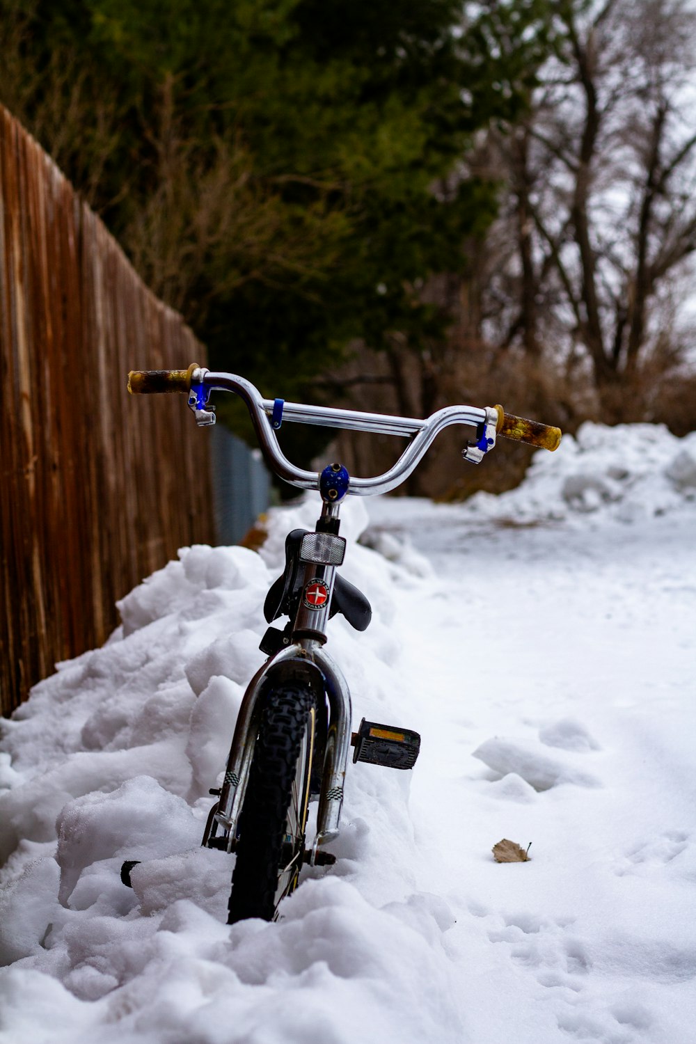 bicicleta preta e cinza no chão coberto de neve durante o dia