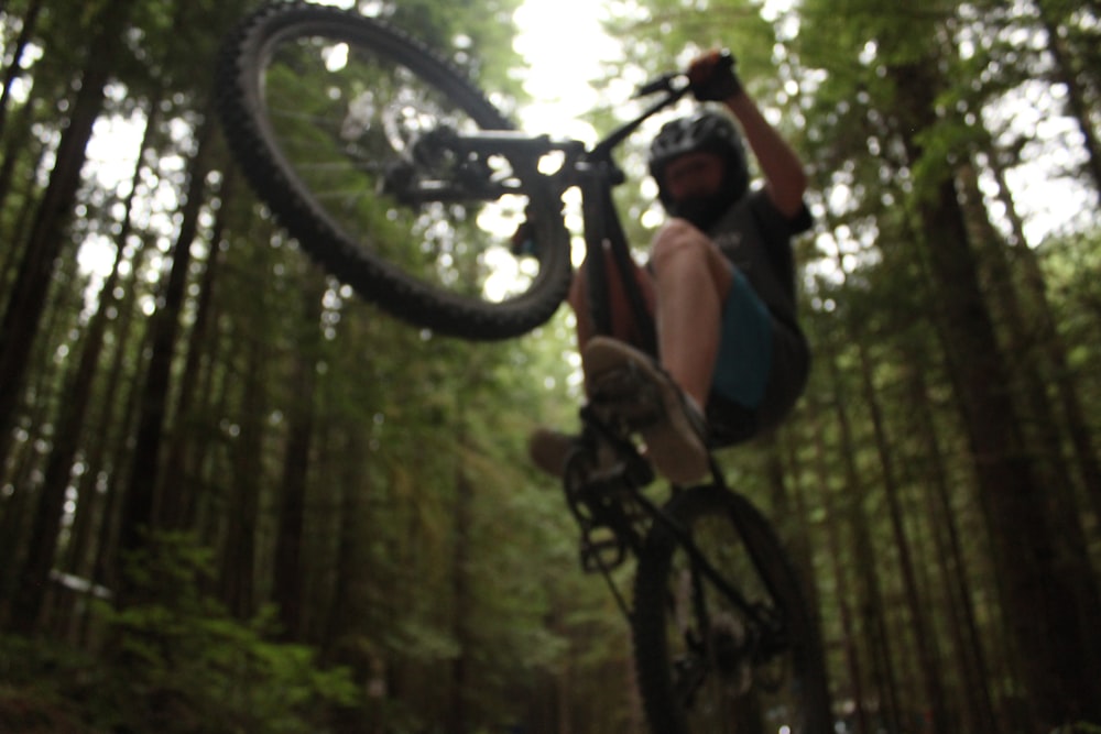 man in blue and red shirt riding black mountain bike