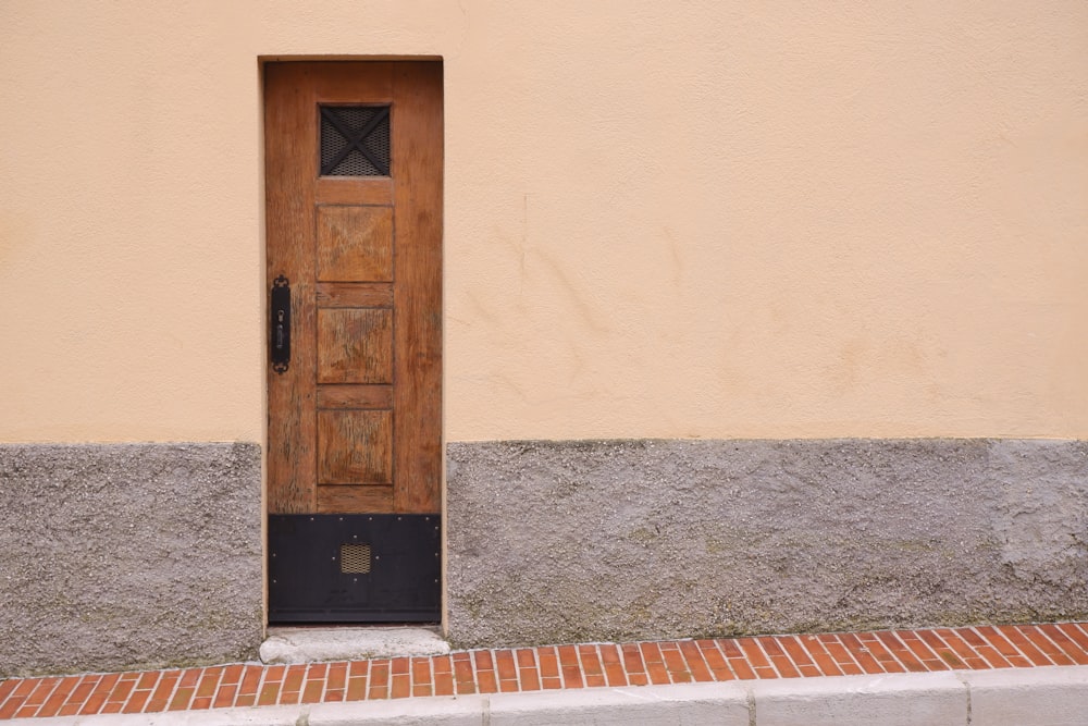 brown wooden door on beige concrete wall