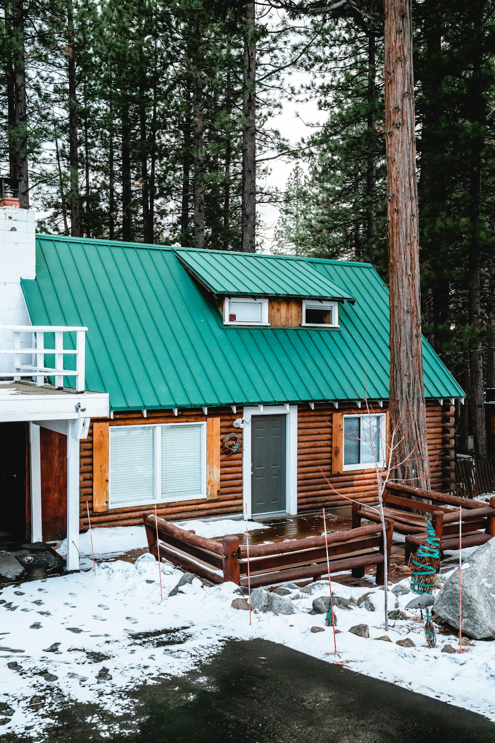 casa di legno verde e marrone vicino agli alberi durante il giorno