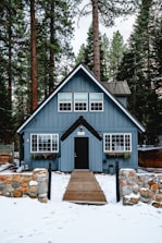 white and brown wooden house near green trees during daytime
