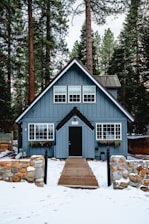 white and brown wooden house near green trees during daytime