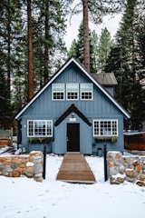 white and brown wooden house near green trees during daytime