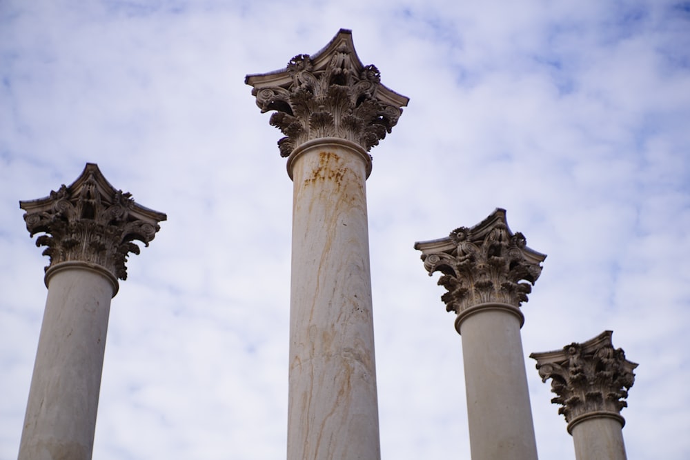 white concrete pillar under white clouds during daytime