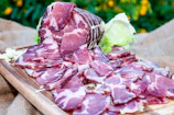 A close-up of premium Iberian ham slices artfully arranged on rustic wooden board.