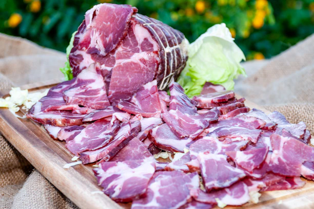 Close-up of premium finely sliced meat arranged on a wooden board.
