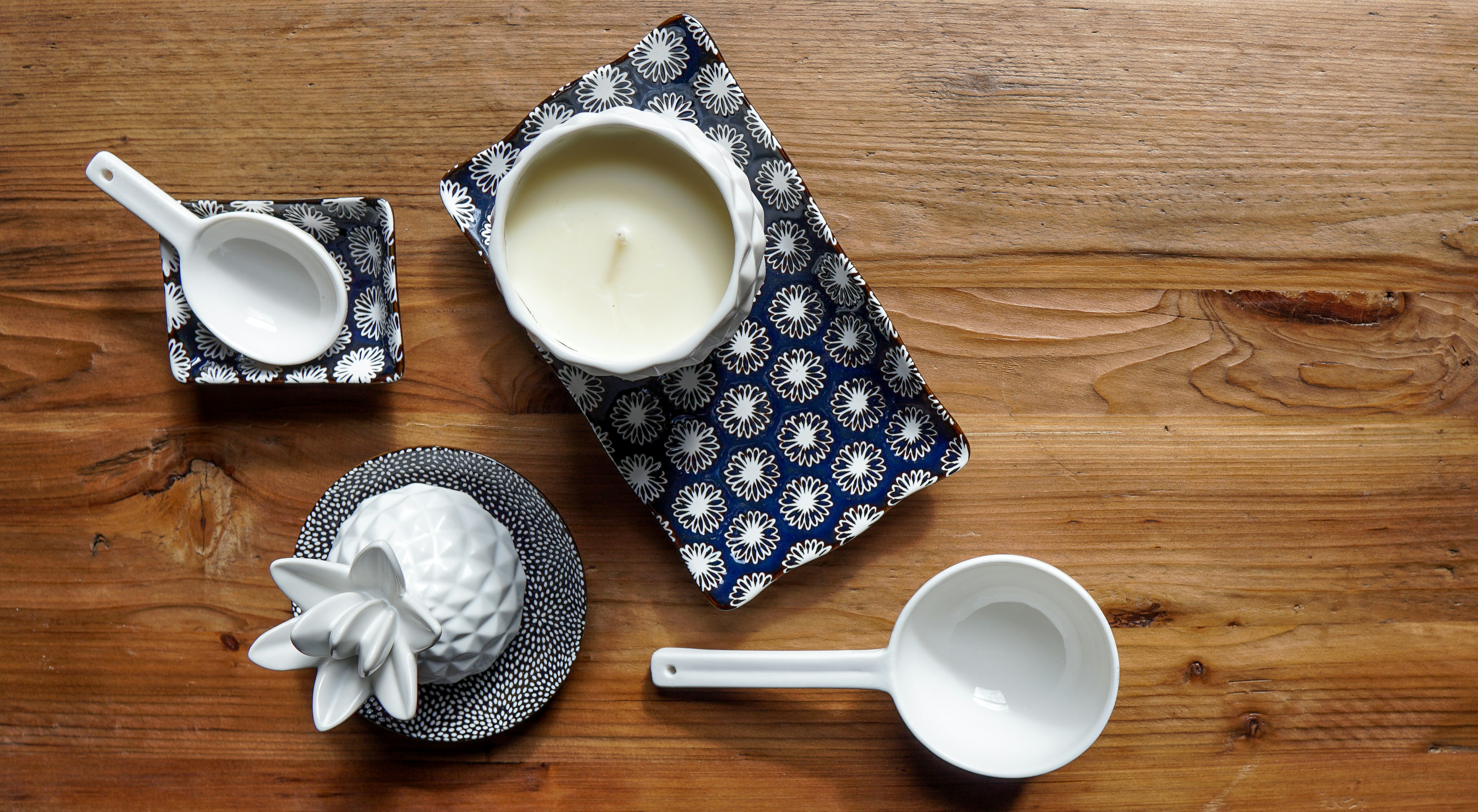 Ceramic mugs and vintage kitchenware on white table, soft daylight