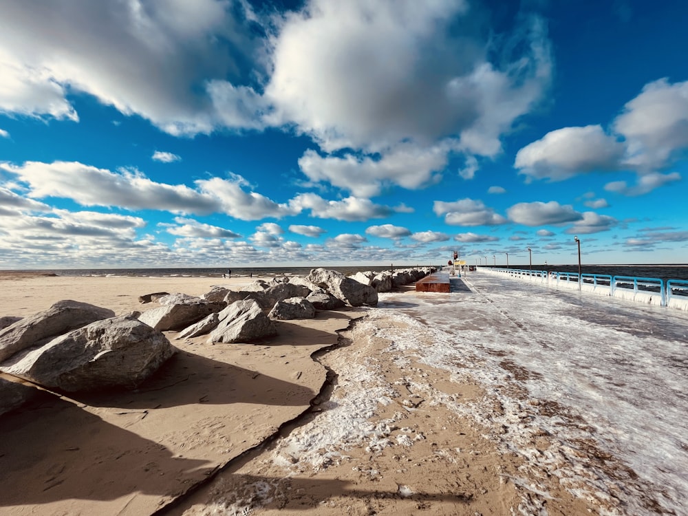 people walking on beach shore under blue sky during daytime