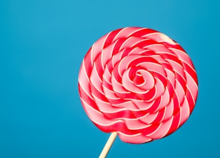 white and red lollipop on blue background