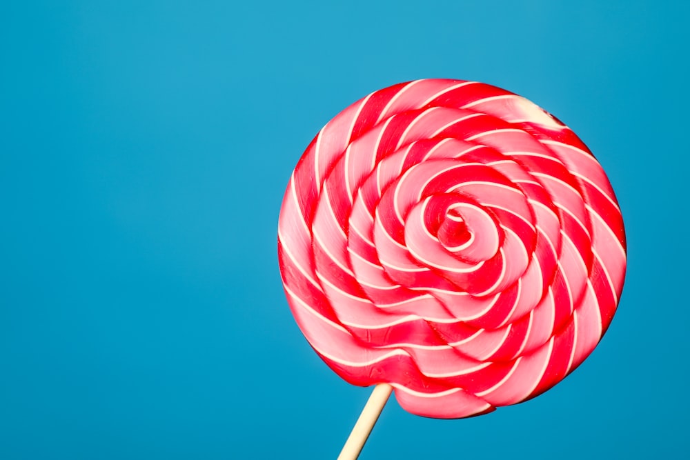 white and red lollipop on blue background