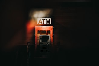 a building with a atm sign lit up at night