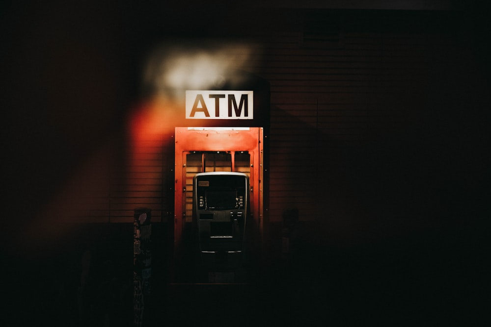 Ein Gebäude mit einem Geldautomatenschild, das nachts beleuchtet wird