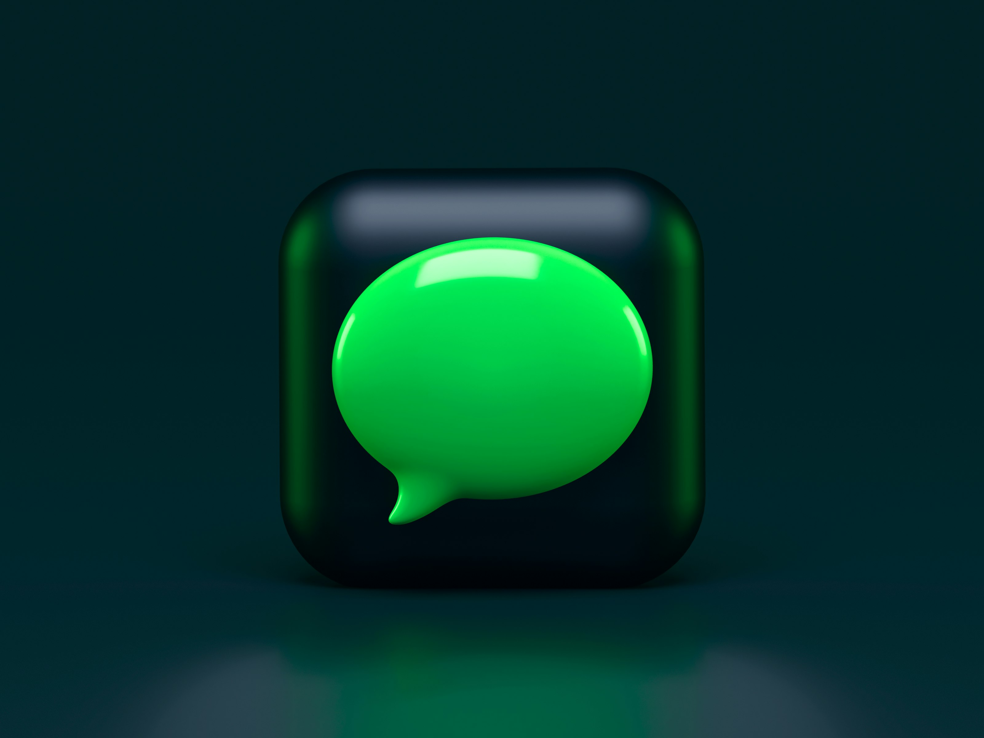 A green chat symbol on a black background.