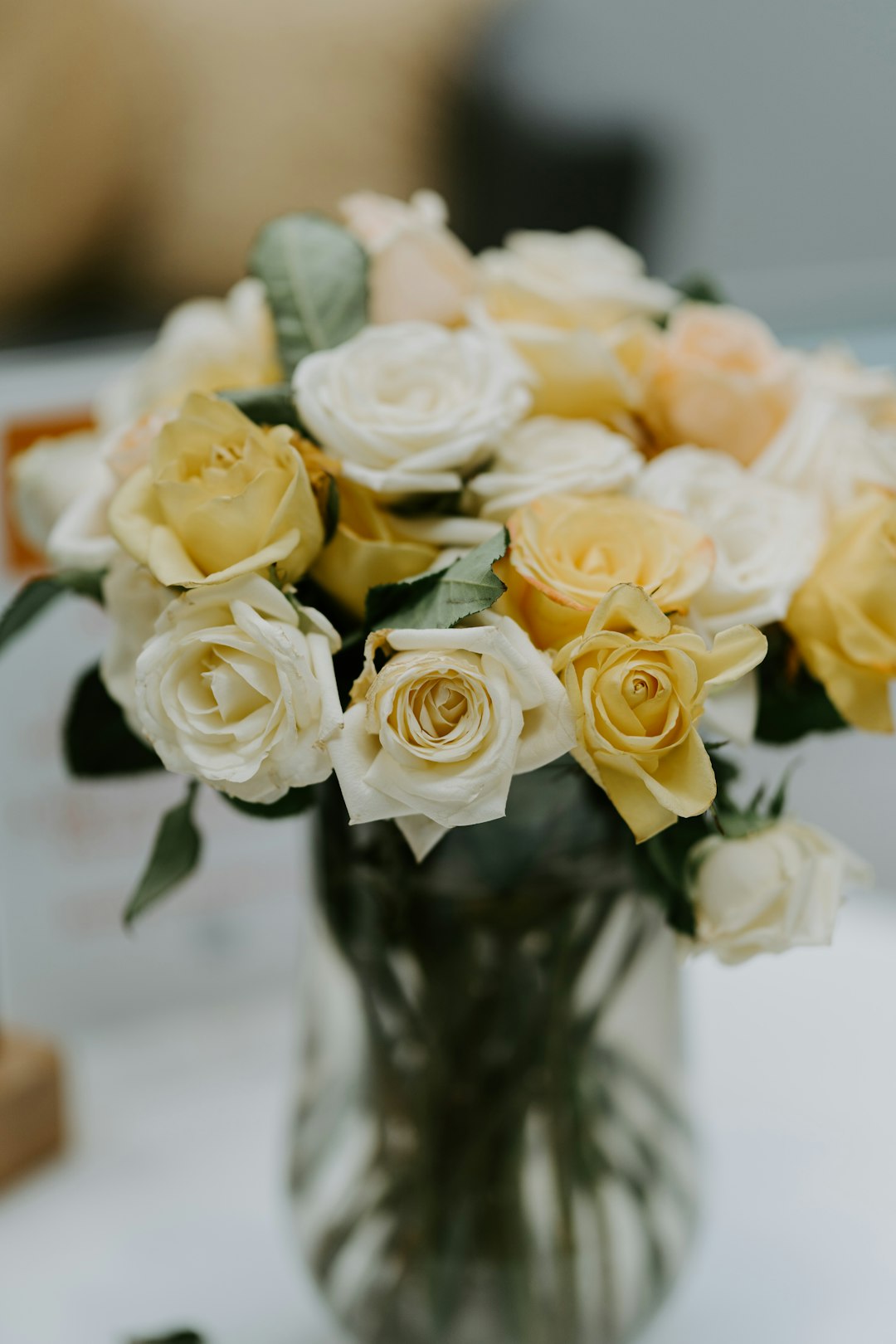 yellow roses in clear glass vase