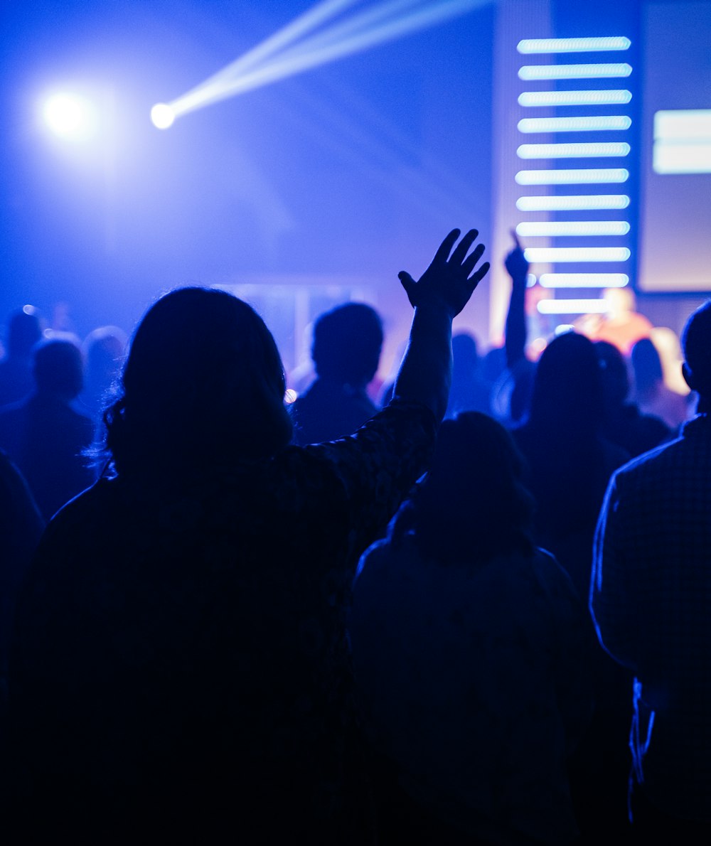 people raising their hands in front of stage