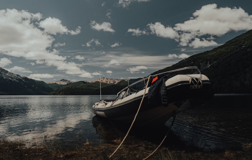 white and black boat on water under cloudy sky during daytime