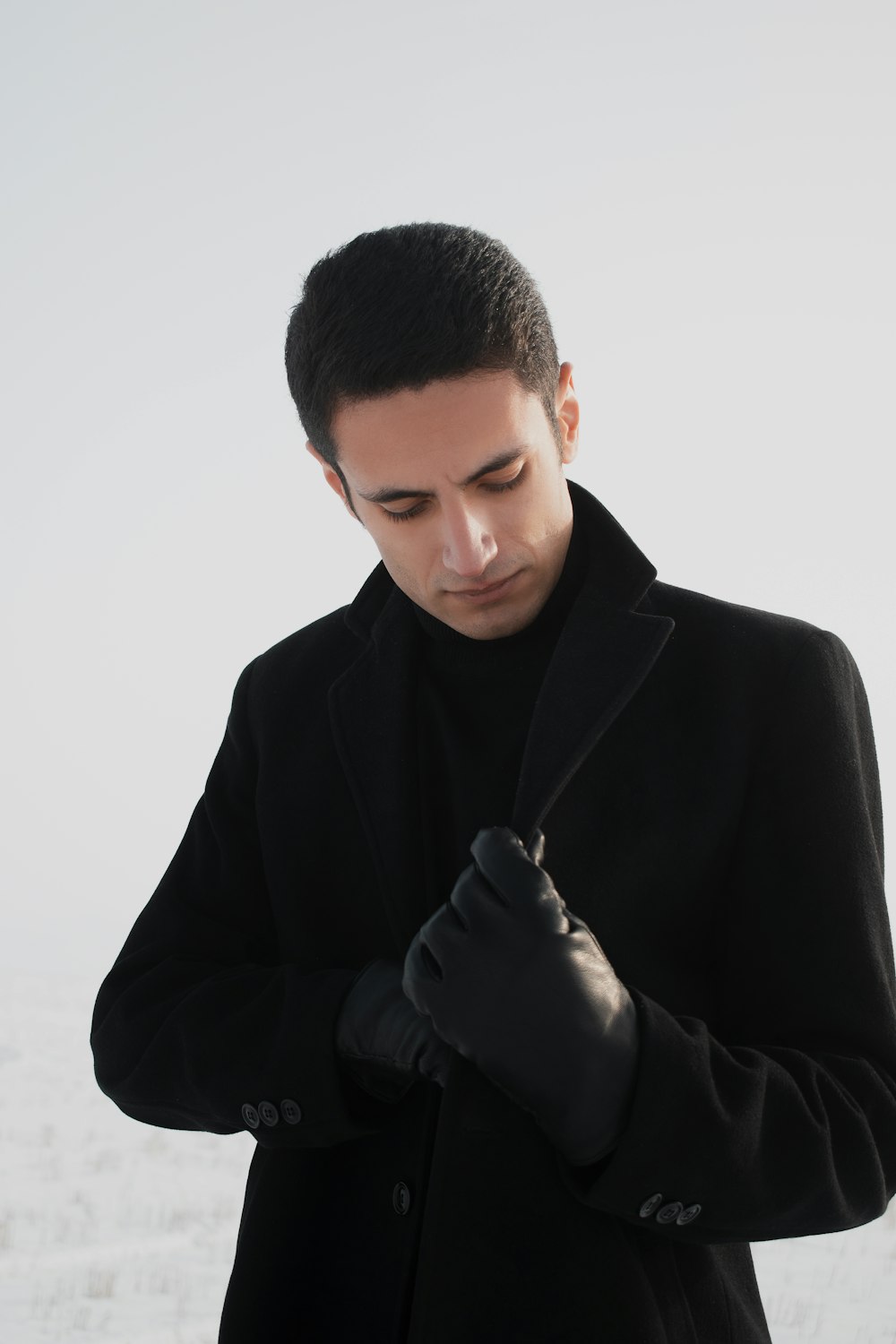 man in black suit jacket holding black pen