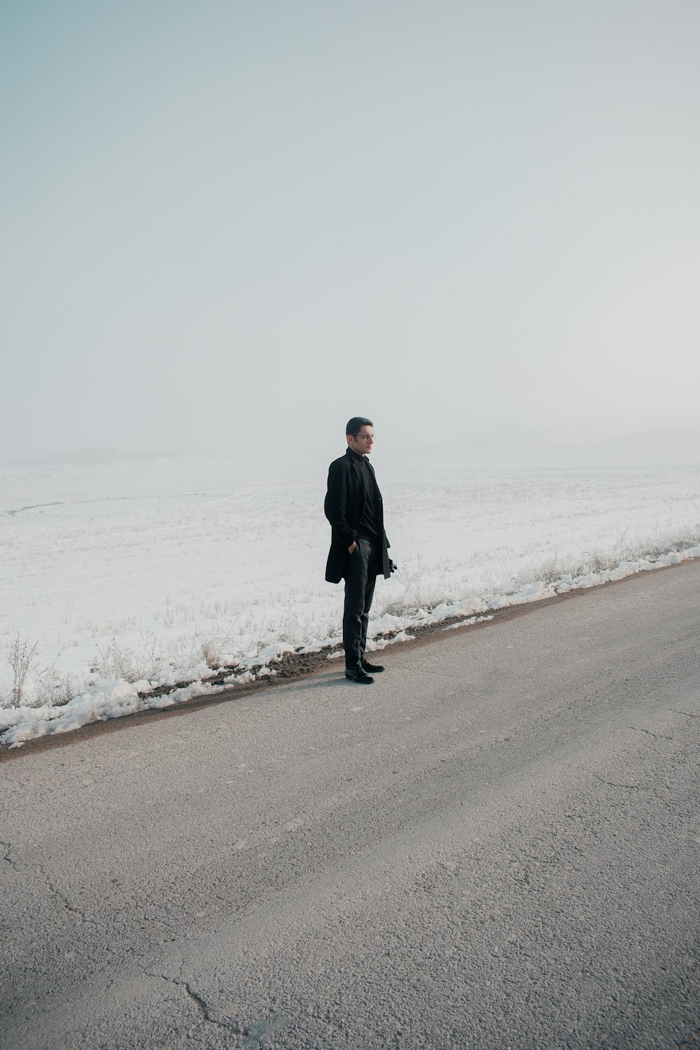 man in black coat walking on beach during daytime