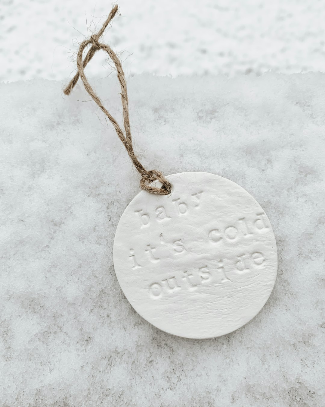 gold round pendant necklace on white snow