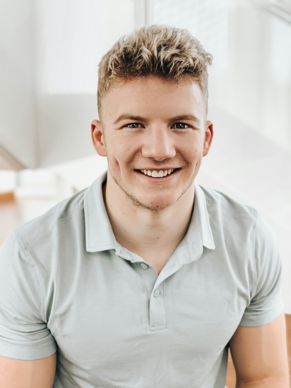 man in gray polo shirt smiling