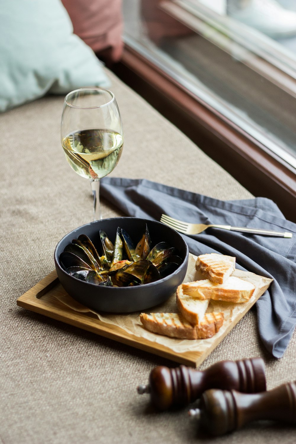 black ceramic bowl with black round plate and clear wine glass on table