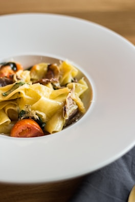 Elegant plating of a pasta dish with fresh herbs and parmesan.