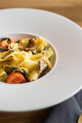 A beautifully arranged plate of pasta with fresh ingredients.
