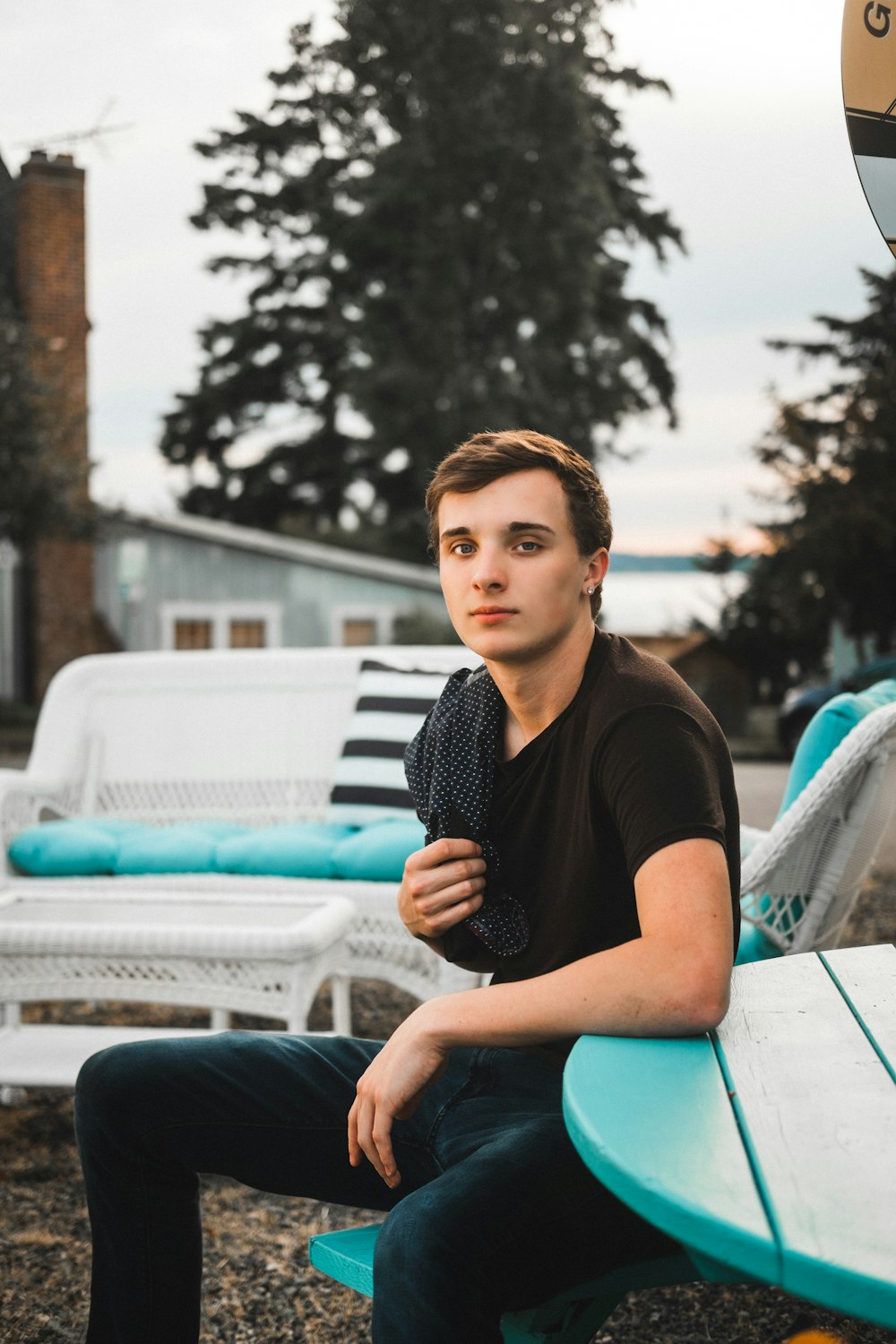 woman in black shirt sitting on white bench during daytime