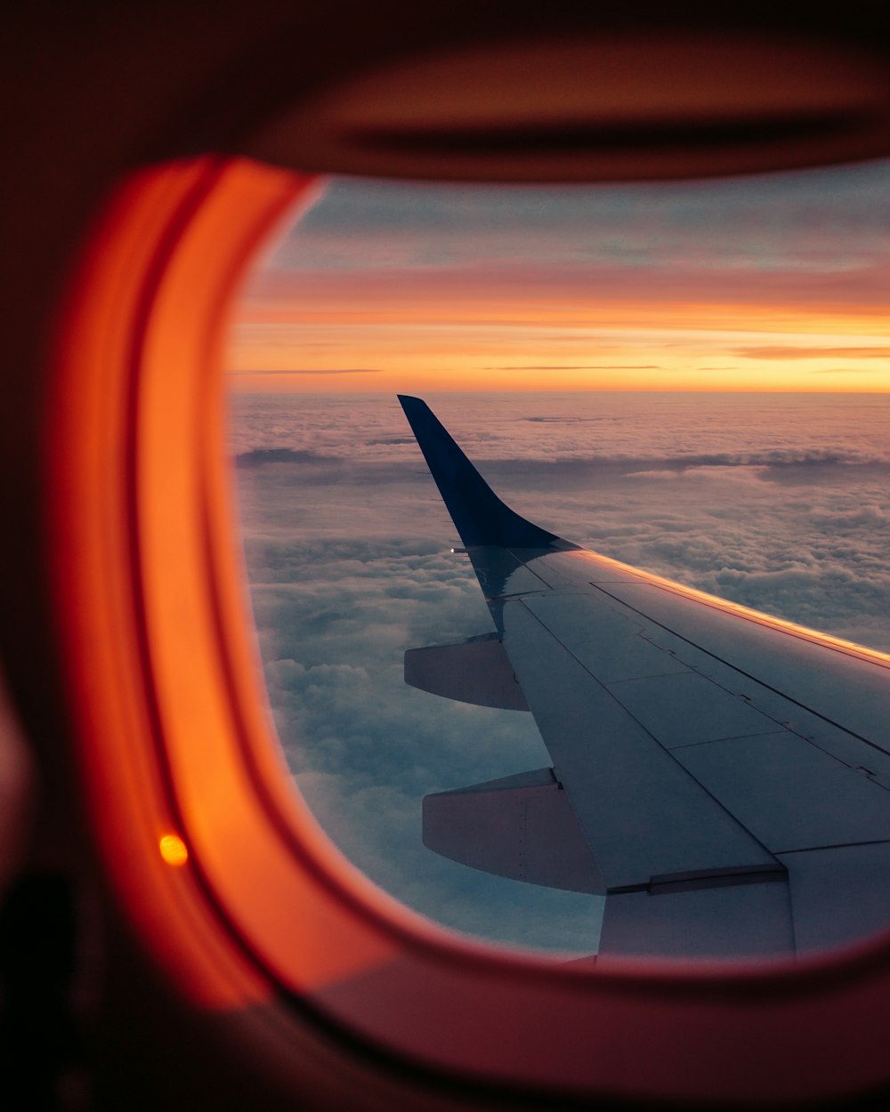 white and orange airplane wing during sunset