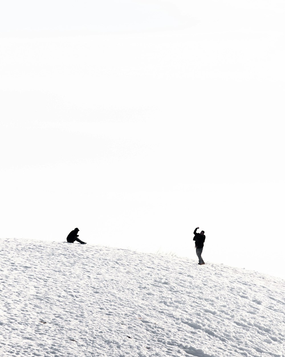 2 personnes marchant sur un sol enneigé pendant la journée