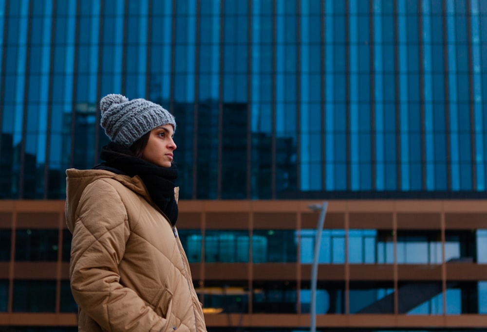 woman in brown jacket wearing gray knit cap