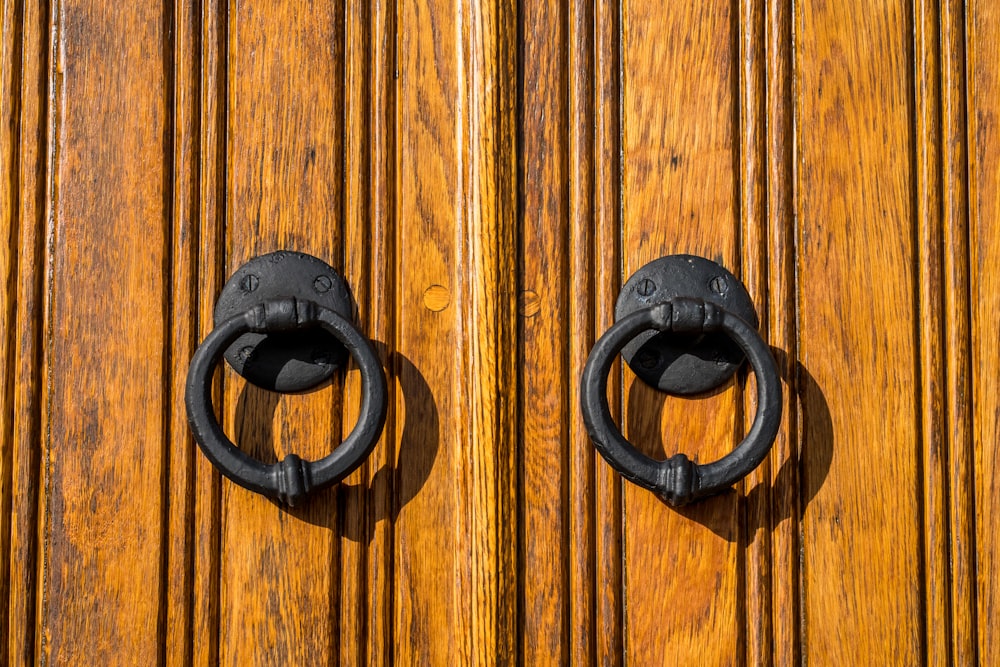 Manija de puerta de acero negro en puerta de madera marrón