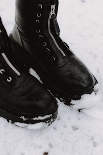 person wearing black leather boots