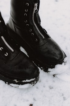 person wearing black leather boots
