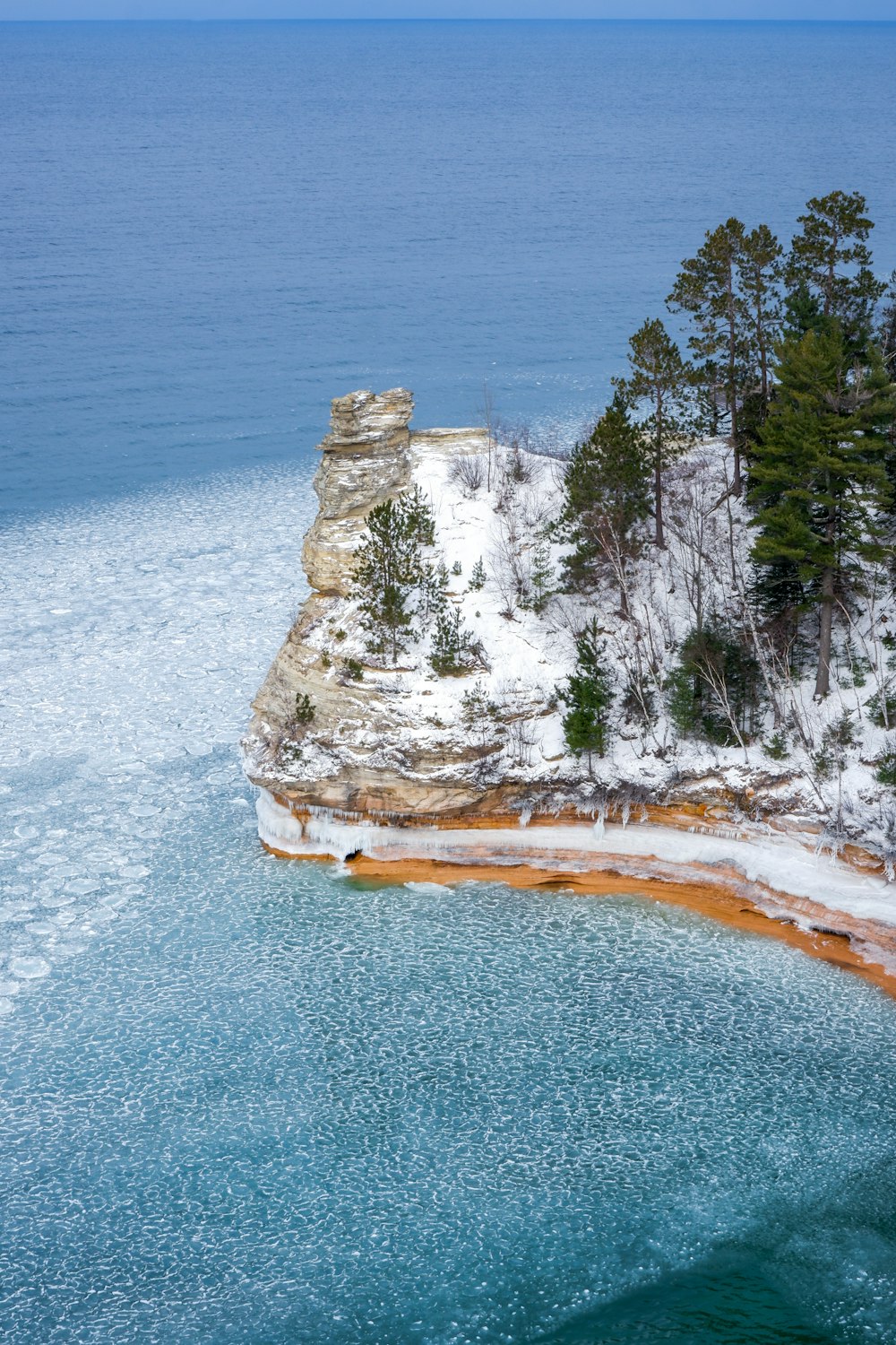 white and brown rock formation near body of water during daytime