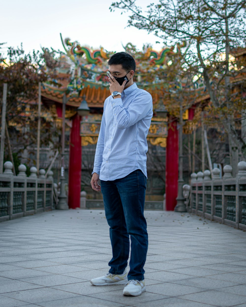 Foto Hombre con camisa de vestir blanca y jeans azules parados en un camino  de hormigón gris durante el día – Imagen Vestir gratis en Unsplash