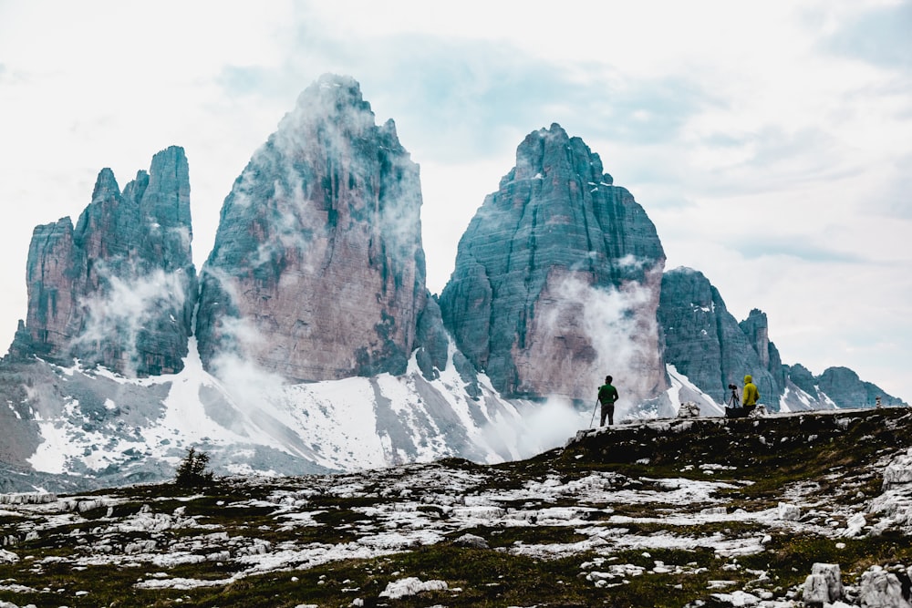 person standing on rocky mountain during daytime