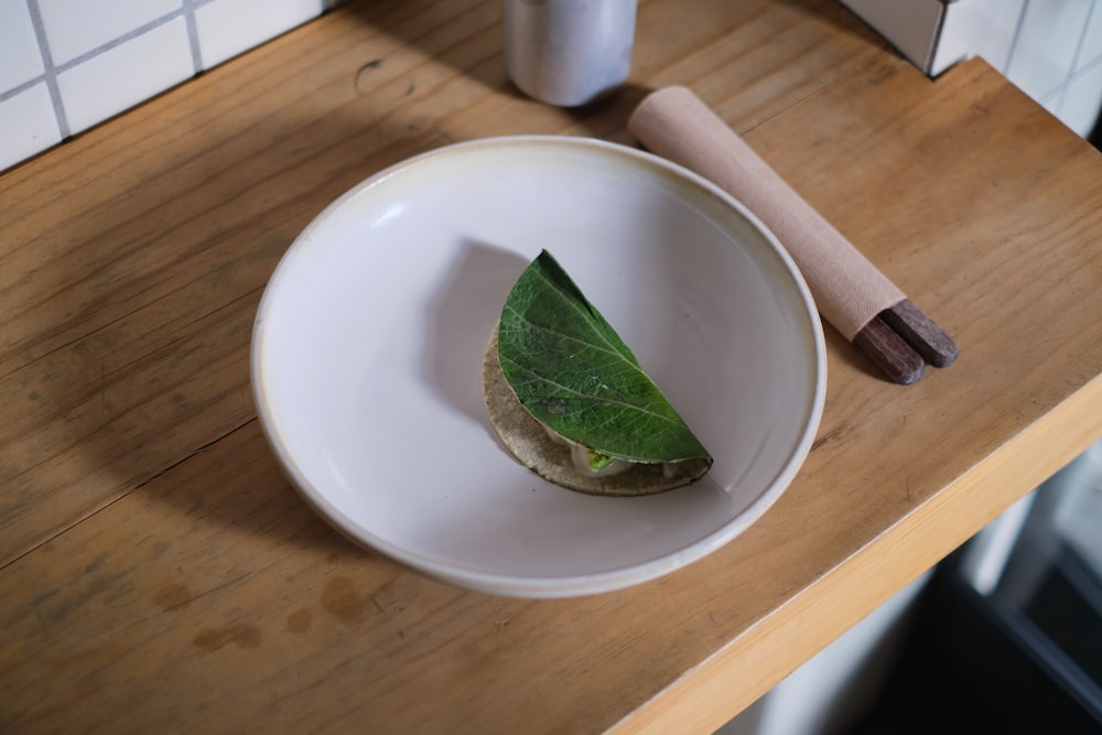 green leaf on white ceramic plate