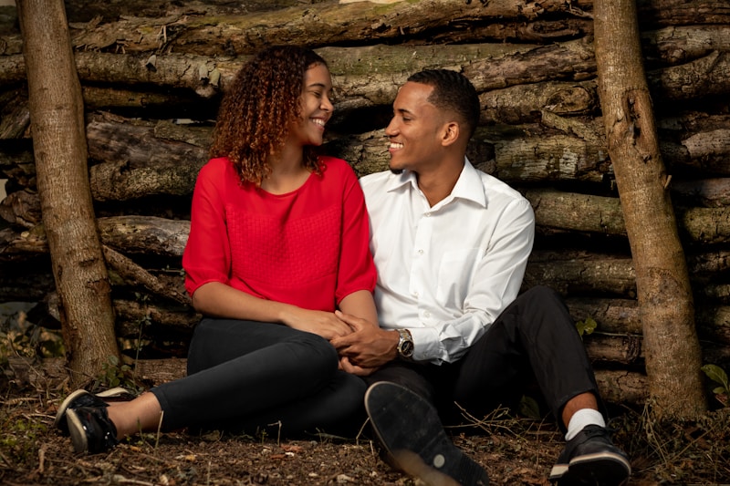 man and woman sitting beside brown tree