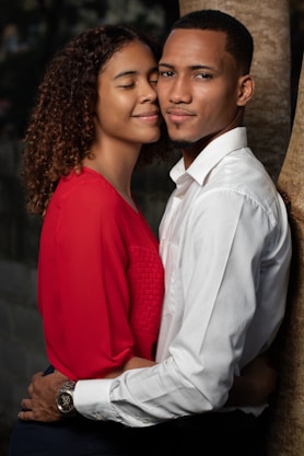 man in white dress shirt beside woman in red long sleeve shirt