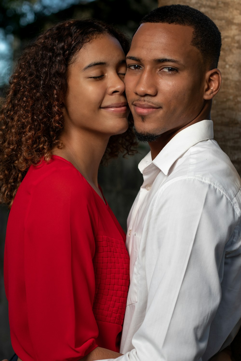 man in white dress shirt beside woman in red long sleeve shirt