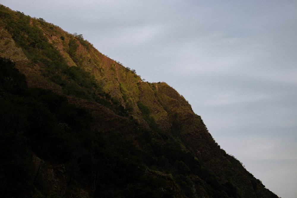 green and brown mountain under white clouds during daytime