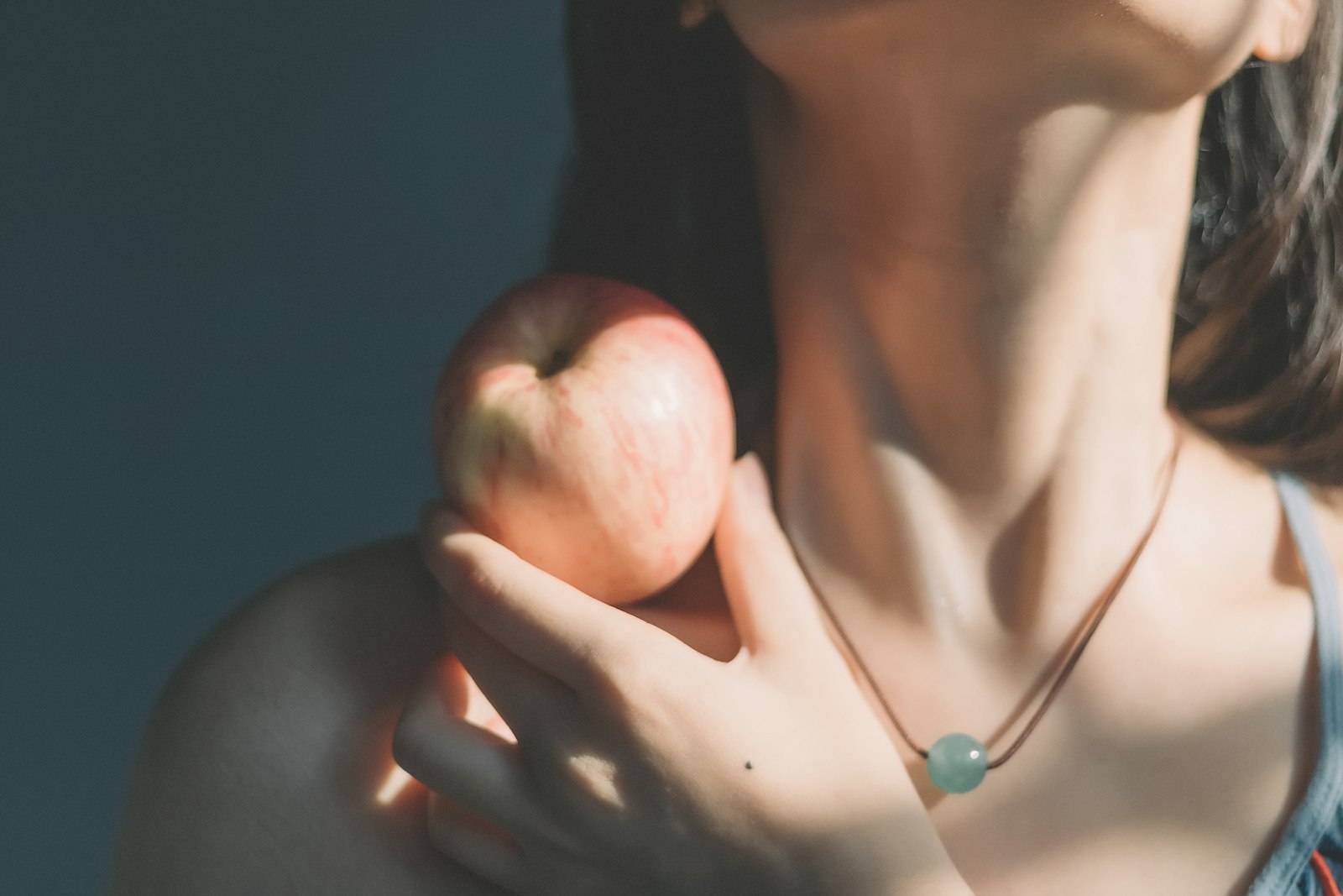 Junge Frau mit Apfel – bei einer Überfunktion arbeitet der Stoffwechsel auf Hochtouren