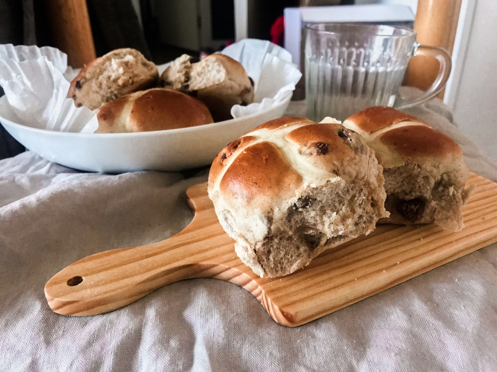 bread on white ceramic plate beside brown wooden spoon