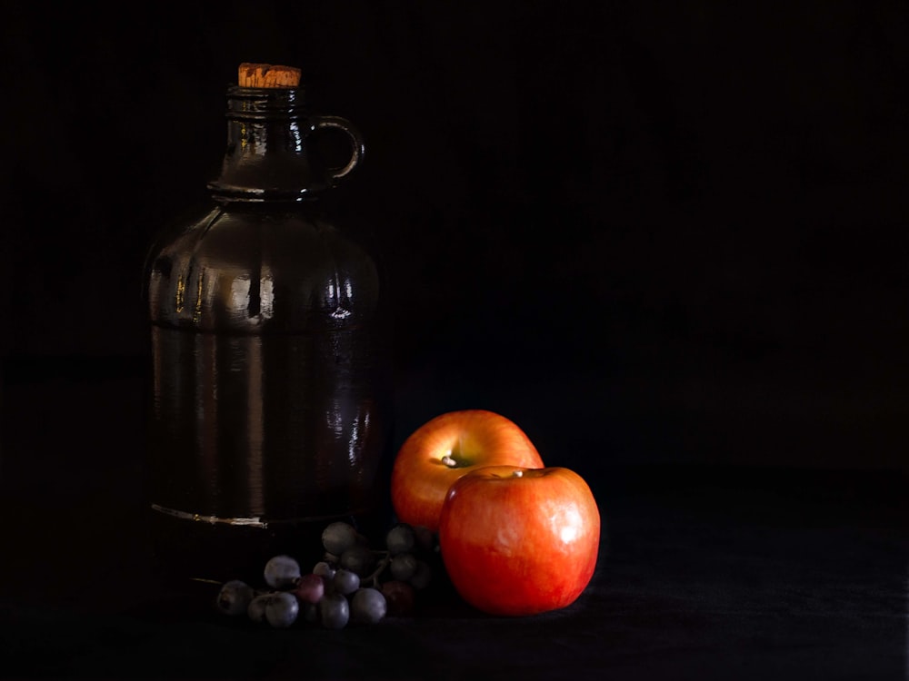 pomme rouge à côté d’un récipient en acier noir