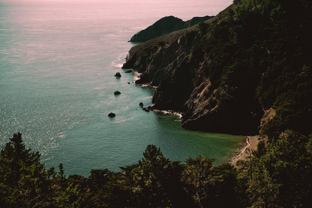 body of water near mountain during daytime